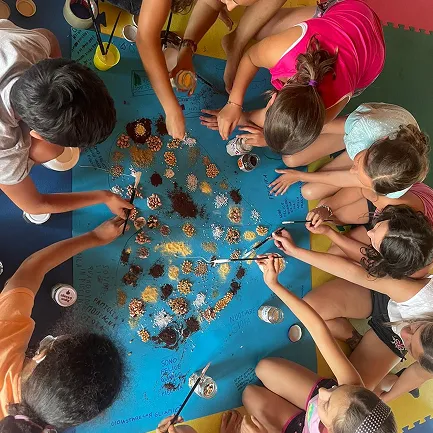 Una vista dall'alto di un gruppo di bambini durante una attività creativa del Grest estivo.